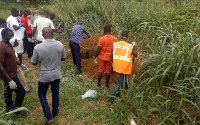 A file photo of people gathered around a decomposing body