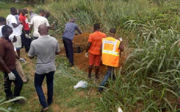 A file photo of people gathered around a decomposing body