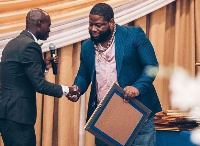 D-Black receiving his award from Dr. UN