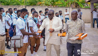 MP for Atwima Kwanwoma, Kofi Amankwa-Manu sharing Maths sets to students