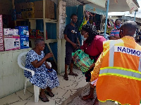 Sandra Owusu- Ahinkorah giving an item an elderly woman