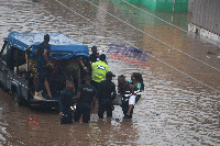 Some police officers to the rescue of people stuck in the floods