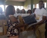 Osei Kofi Lambeth presenting the items to the headmistress of Amani