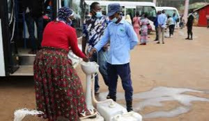 Passengers wash hands before boarding a bus at Nyabugogo Taxi Park in Kigali