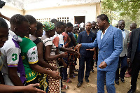 President Faure Gnassingbe (right) shakes hand with people queuing to vote in Kara