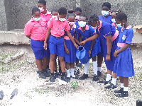 School pupils watering a plant