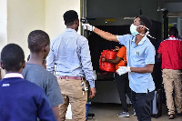 A worker checks the temperature of travelers at the border post with Kenya in Namanga, FILBERT RWEY