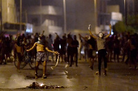 Protesters gesture as they block a street in the Sidi Hassine suburb on the outskirts of Tunis