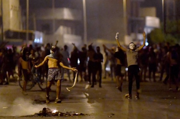 Protesters gesture as they block a street in the Sidi Hassine suburb on the outskirts of Tunis