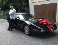 Jerry John Rawlings poses beside the car