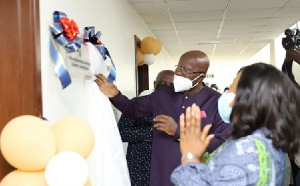 Mr Agyeman unveiling the plaque, with Mrs Botchwey clapping