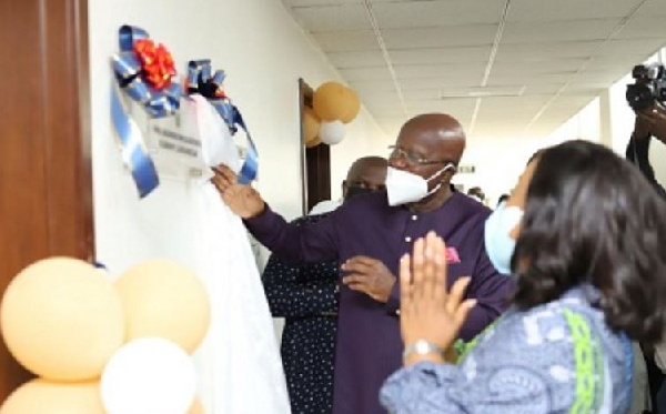 Mr Agyeman unveiling the plaque, with Mrs Botchwey clapping