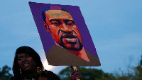 Black Lives Matter protester hold placard wit foto of Geroge Floyd