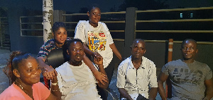 Sandra Mantey standing behind Prophet Nigel, her mom on his right with other members of their family