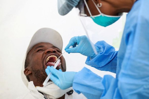 A medic takes a person's sample for testing