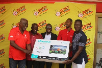 Jacob Tokoli being presented the 32-inch LED television by officials from Happy FM