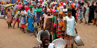 People wait to receive goods from volunteers to the underprivileged during the partial lockdown