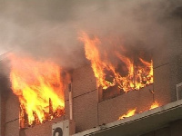 Flames of fire emanating from a building on fire