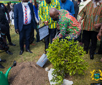 The president planting a tree to cut sod for the nationwide tree planting project