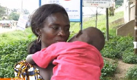 Monica Nyarko carrying her 4-year-old child who was defiled by an adult male.