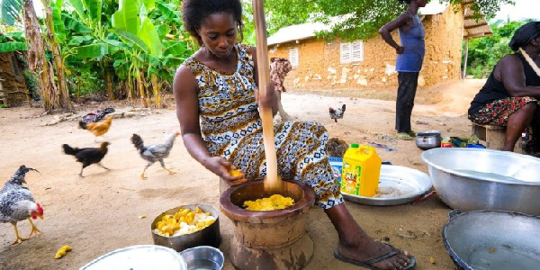 File Photo: A woman pounding palmnuts in a local kitchen