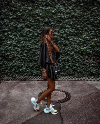 Lady rocking her chunky sneakers with a silk dress and side bag