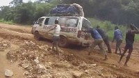 A car seen stuck on the road with people pushing it