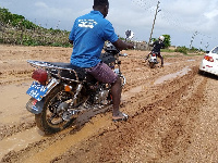 Photo of some motorcyclists plying the muddy road