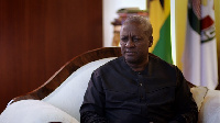 President John Mahama seated in his office