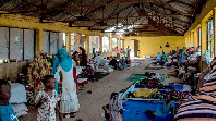 Women and children gather in a building at a camp for the internally displaced in al-Suwar,