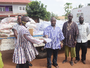 Chief of Gbetsile (middle) presenting the items and money to an elder of the town for distribution