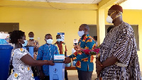 Bismark Nyarko, second from right, presenting the items to the health workers