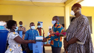 Bismark Nyarko, second from right, presenting the items to the health workers