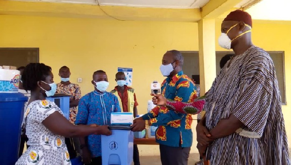 Bismark Nyarko, second from right, presenting the items to the health workers