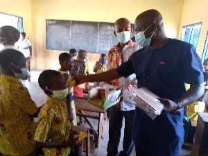 Simon Kweku Tetteh distributing some items to some students