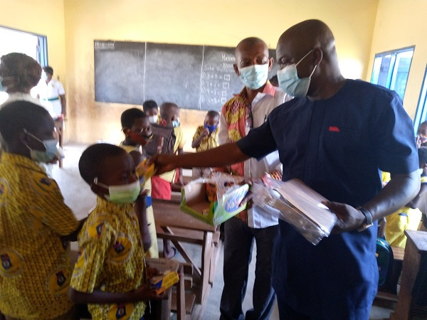 Simon Kweku Tetteh distributing some items to some students