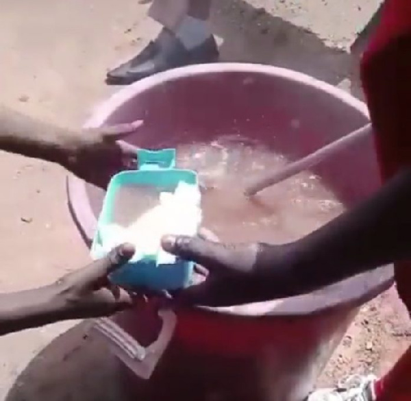 Image from a viral video in which a caterer is spotted serving 'eba' with soup