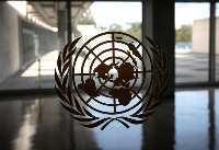 The United Nations logo is seen on a window in an empty hallway at United Nations headquarters