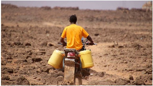 A man ferries water to his home in Kenya’s drought-hit Marsabit County