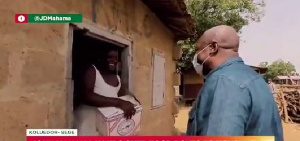 Former President John Dramani Mahama gives out a box containing food items to a woman