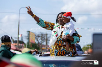 Jane Naana Opoku-Agyemang holding a child during a campaign tour