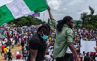 Protesters raise a flag during a march through the Lagos district of Surulere