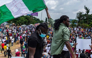 Protesters raise a flag during a march through the Lagos district of Surulere