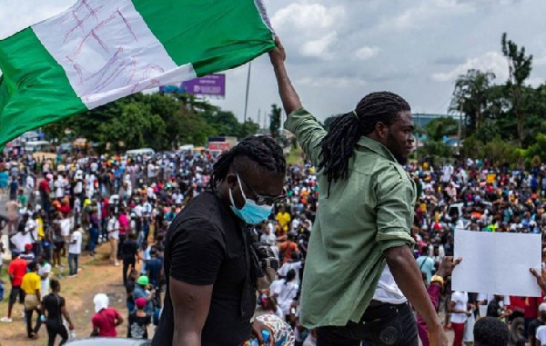 Protesters raise a flag during a march through the Lagos district of Surulere