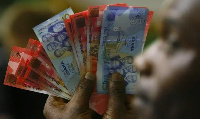 A man holding cedi notes