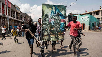 Demonstrators carry a poster honouring the DRC's armed forces during a protest in Goma