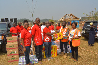 Mr. Eldon Otu (middle) presenting the items to the NADMO officials