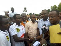 Hon. Simon Osei Mensah handing the envelope to Amos Frimpong