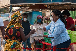 Naa Momo Lartey gifts a woman with some food stuff