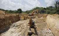 An excavator distroying the land in the name of the search for gold